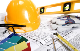 Hard hat and remodeling equipment laying on top of blueprints