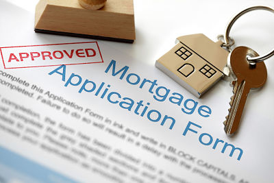 Mortgage application form with stamp saying "approved" and keys