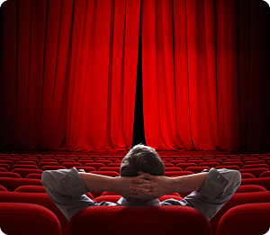 Man in theater relaxing back with curtain slightly open