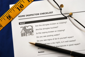 Home inspection checklist with pen and ruler and glasses on top