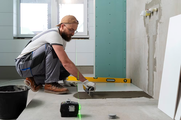 Man Installing Tile on the Floor of a Basement